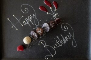 Elegant dark birthday celebration with moody atmospheric lighting